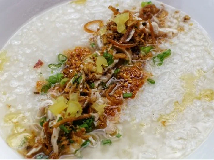 Bubur Nasi Ayam ditabur ayam suwir, bawang goreng dan daun bawang