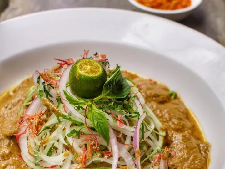 Laksa Johor Kampung Chelet dengan kuah ikan pekat, ulam, bawang dan limau kasturi