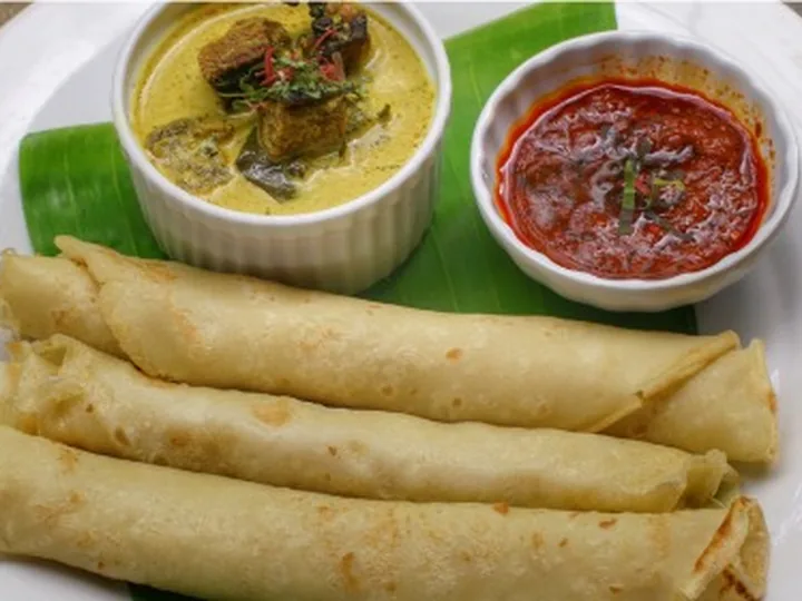 Lempeng kelapa digulung dihidang bersama gulai lemak cili api dan sambal